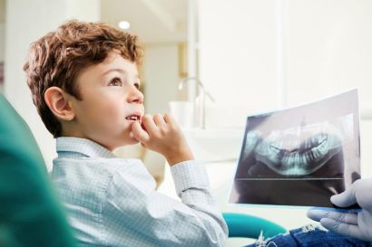 Einem Kind wird von einem Kieferorthopäden die Behandlung erklärt