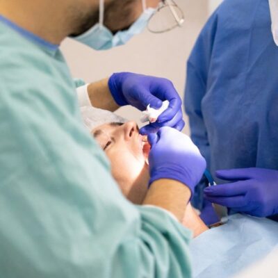 Ein Patient mit einer gravierenden Fehlstellung wird von zwei Chirurgen im Kiefer operiert